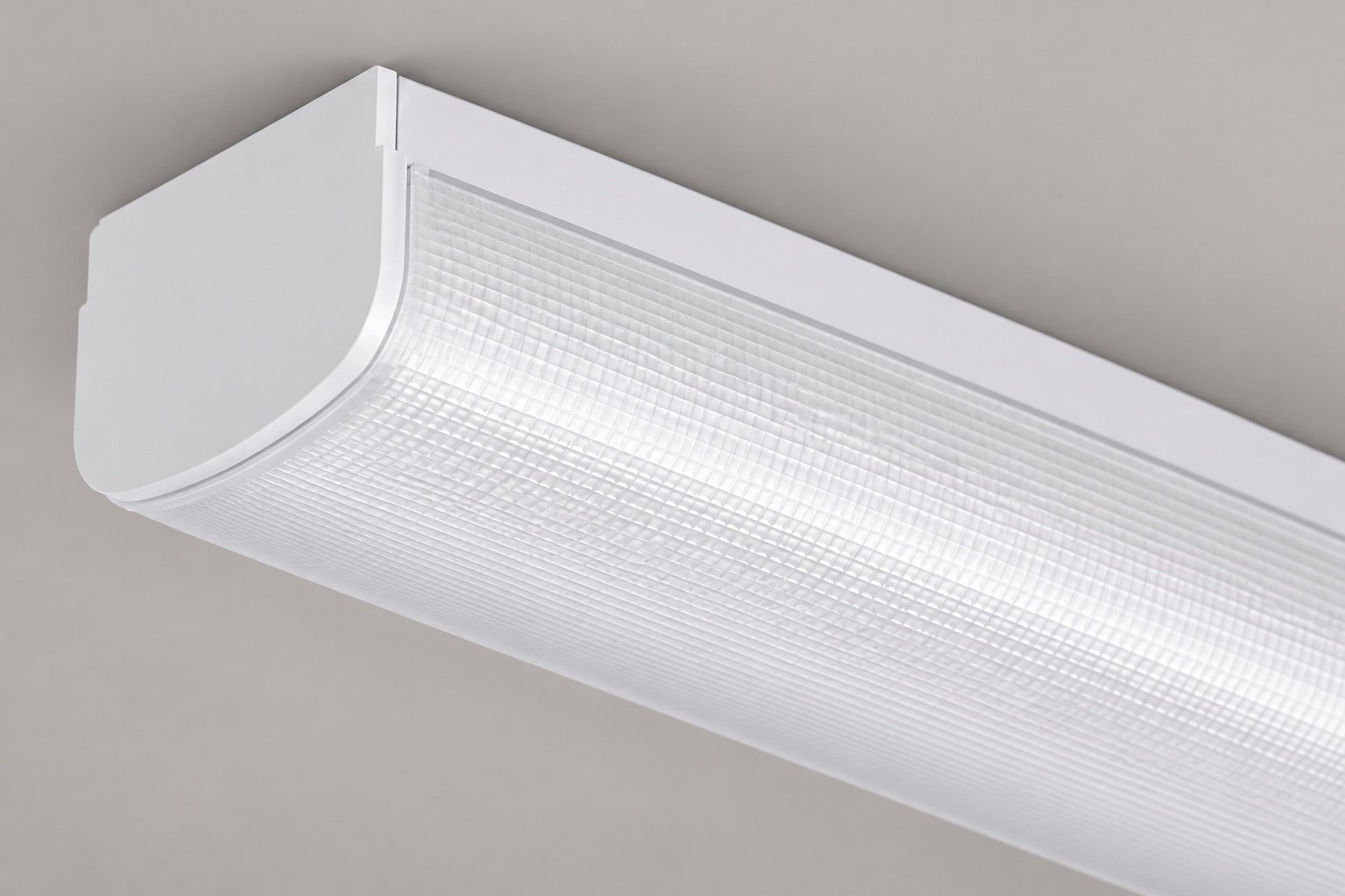Illustrative close-up of a prismatic wraparound diffuser and end cap.