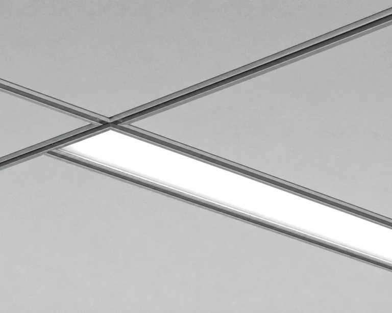 AM20G recessed LED luminaire integrated into a T-grid ceiling with illuminated linear diffuser